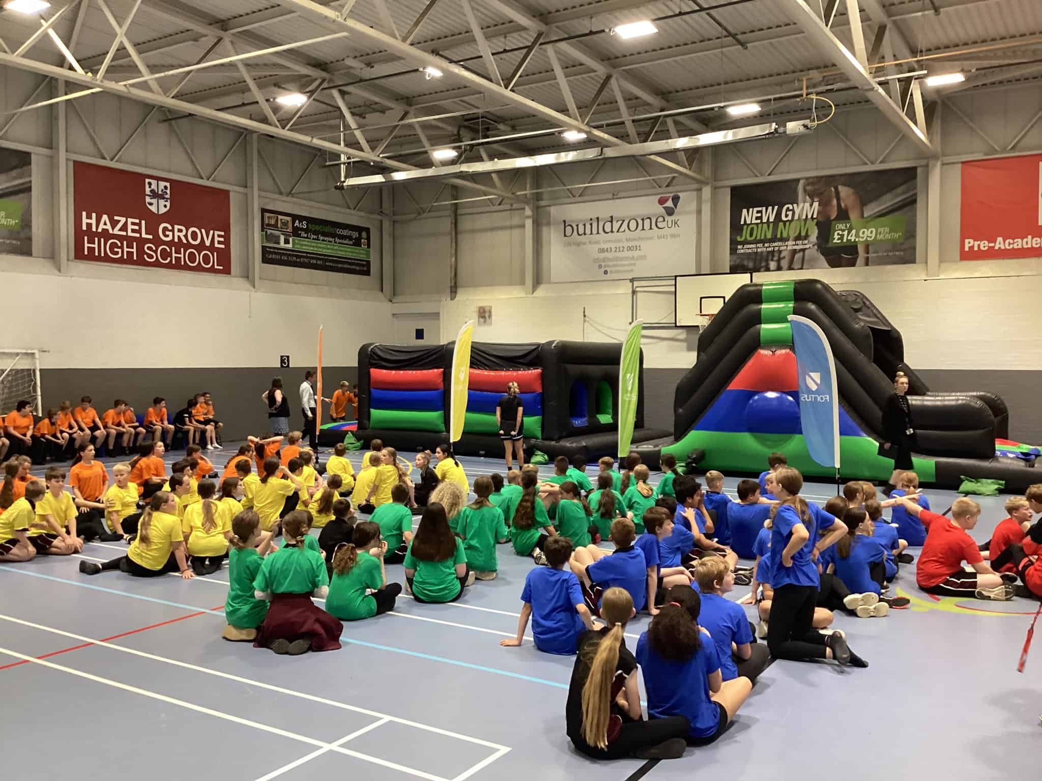 Hazel Grove High School students sit in their houses ready to take on the inflatable obstacle course