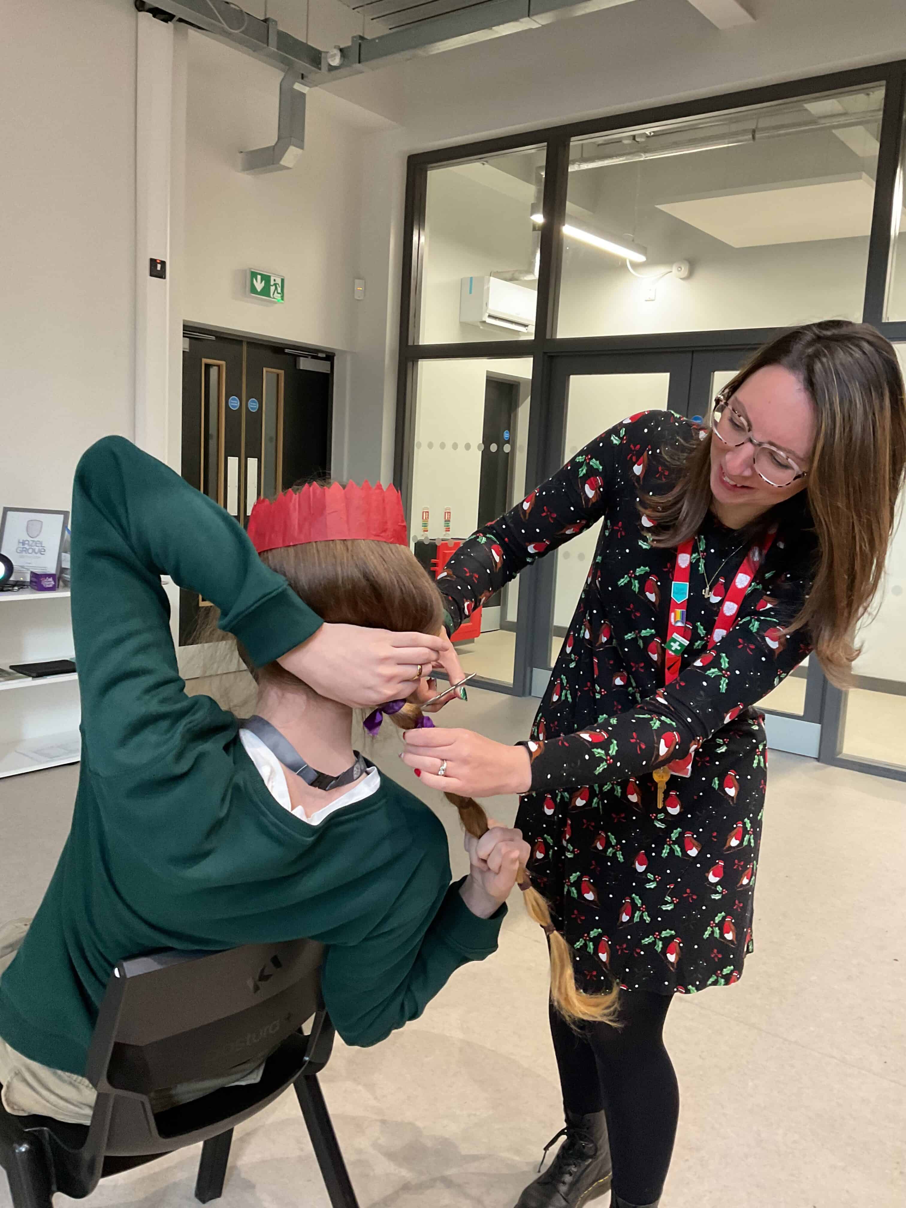 Mrs Lambert, Director of Hazel Grove Sixth Form, cuts off William's hair to donate to the Little Princess Trust